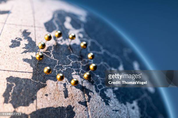 europäische union-goldene stifte auf korkbrettglobe - european union stock-fotos und bilder