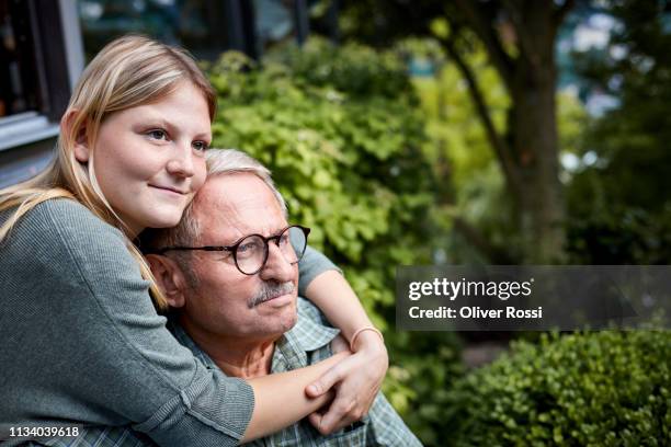 adult granddaughter embracing grandfather in garsden - multi generation family thinking stock pictures, royalty-free photos & images