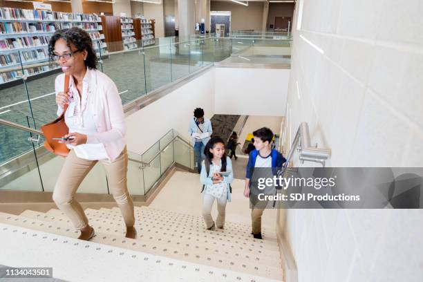 teacher and students ascend stairs to school library - step brother stock pictures, royalty-free photos & images