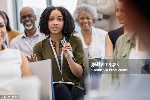 a mulher de negócios nova pergunta durante o seminário - summit meeting - fotografias e filmes do acervo