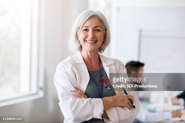 portret van zelfverzekerde vrouwelijke arts - doctor female portrait stockfoto's en -beelden