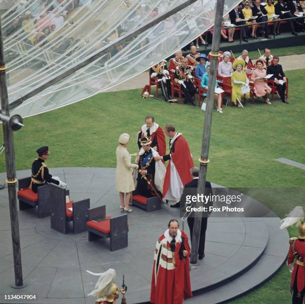 Prince Charles kneels before the Queen during the ceremony of his investiture as Prince of Wales at Caernarfon Castle, Gwynedd, Wales, 1st July...