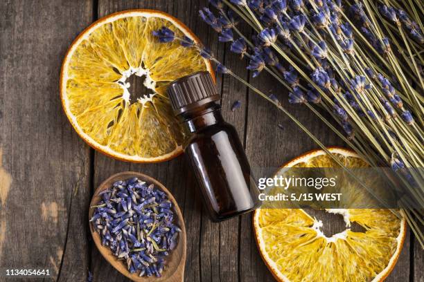 ätherischer öllawinen und orange trocken auf einem holztisch, oben ansicht - aromatherapie stock-fotos und bilder