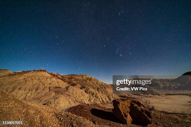 Orion and the winter stars and constellations rising over the moonlit badlands of Dinosaur Provincial Park, Alberta, on November 27, 2017 Orion is at...