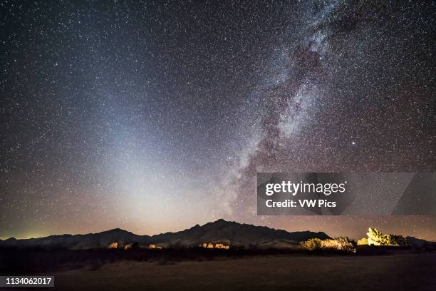 Depictions of two kinds of dust in space: At left the pyramid-shaped glow of Zodiacal Light caused by sunlight reflecting off interplanetary dust in...