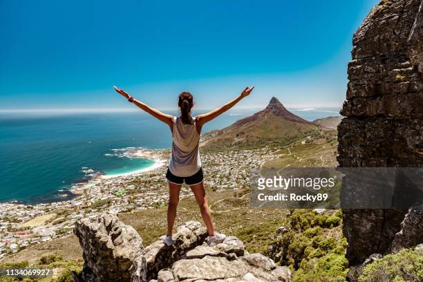 touristenländerin wandert tafelberg mit blick auf löwenkopf, kapstadt, südafrika - table mountain cape town stock-fotos und bilder