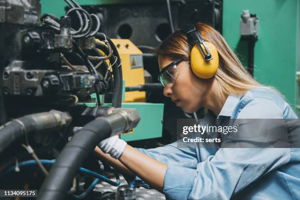 professionele technische arbeider vrouw die werkt met de productielijn machine - oorbeschermer stockfoto's en -beelden