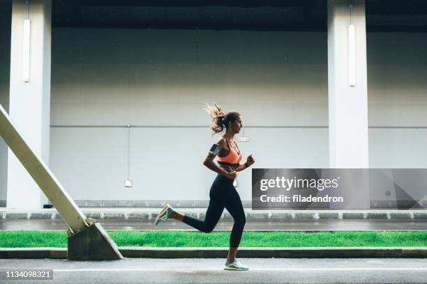 sportswoman running in the city - center athlete stock pictures, royalty-free photos & images