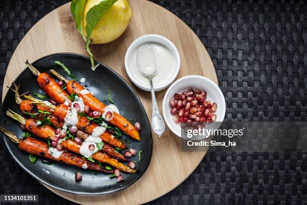 carote arrosto dolce con salsa tahini, melograno - glassa foto e immagini stock