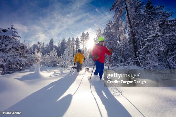 schneeschuhwandern am sonnigen tag. - schneeschuhwandern stock-fotos und bilder