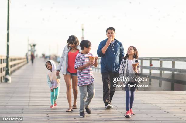 familie isst eis auf einer strandpromenade - filipino family eating stock-fotos und bilder
