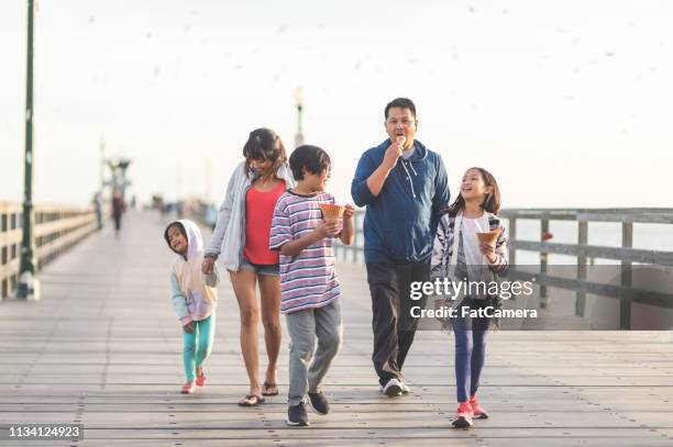 familie eten ijs op een strandpromenade - boardwalk stockfoto's en -beelden