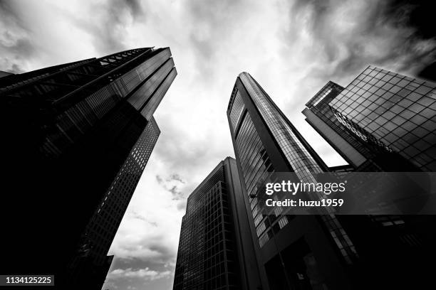 upward view of skyscrapers - オフィスビル stock-fotos und bilder