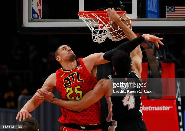 Derrick White of the San Antonio Spurs dunks against Alex Len of the Atlanta Hawks in the first half at State Farm Arena on March 06, 2019 in...