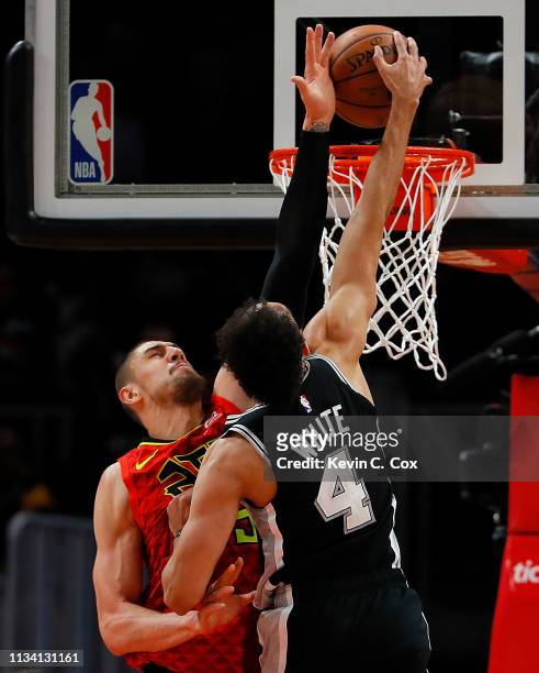 Derrick White of the San Antonio Spurs dunks against Alex Len of the Atlanta Hawks in the first half at State Farm Arena on March 06, 2019 in...
