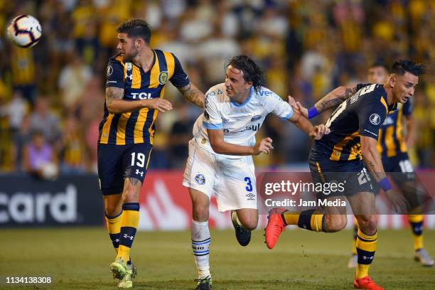 Miguel Barbieri of Rosario Central heads the ball against Pedro Geromel of Gremio during a group H match between Rosario Central and Gremio as part...