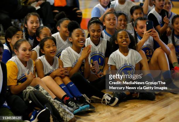 Young basketball players listen as Golden State Warriors' Stephen Curry takes part in a dedication ceremony for the newly-refurbished basketball...