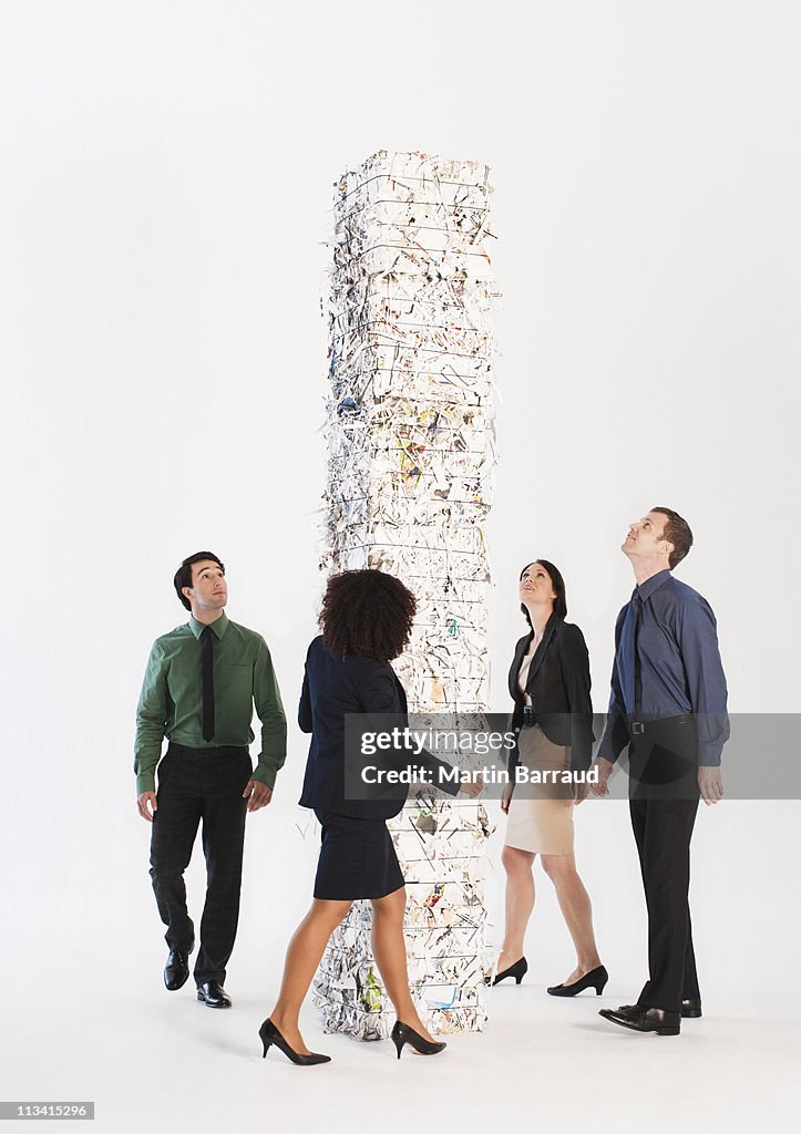 Business people looking at stack of paper bales