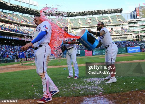Elvis Andrus of the Texas Rangers and Rougned Odor dump the coolers of water on Asdrubal Cabrera celebrating the win against the Chicago Cubs at...
