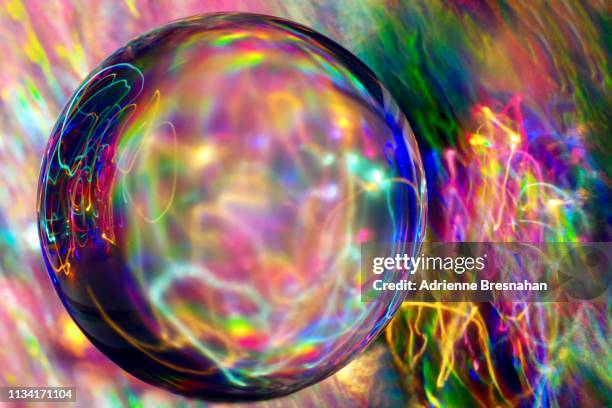 crystal ball and squiggling light trails - magic ball stock-fotos und bilder