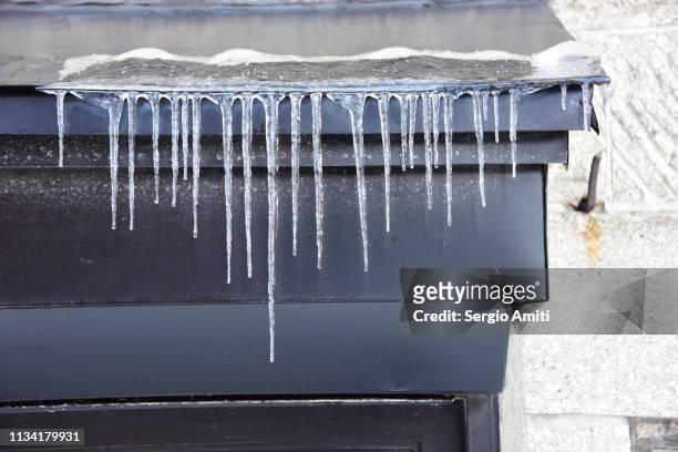 icicles on a metal roof - icicles stock pictures, royalty-free photos & images