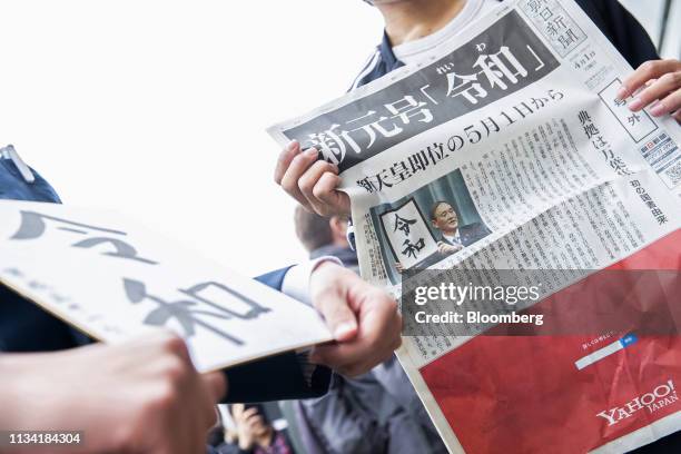 Man holds a copy of an extra edition of the Asahi Shimbun newspaper reporting on the announcement of the name of Japan's next imperial era "Reiwa" in...