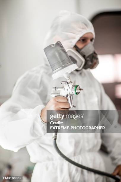 car painter holding up a paint gun in a painting booth of a body shop - spray booth stock pictures, royalty-free photos & images