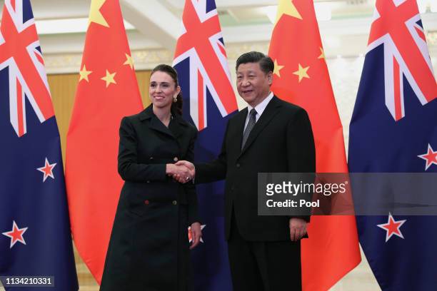 Chinese President Xi Jinping, right and New Zealand Prime Minister Jacinda Ardern, left shake hands before the meeting at the Great Hall of the...