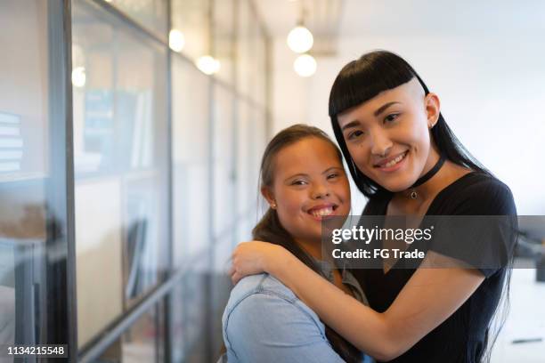 Business colleagues embracing (including Special Needs woman) - Portrait