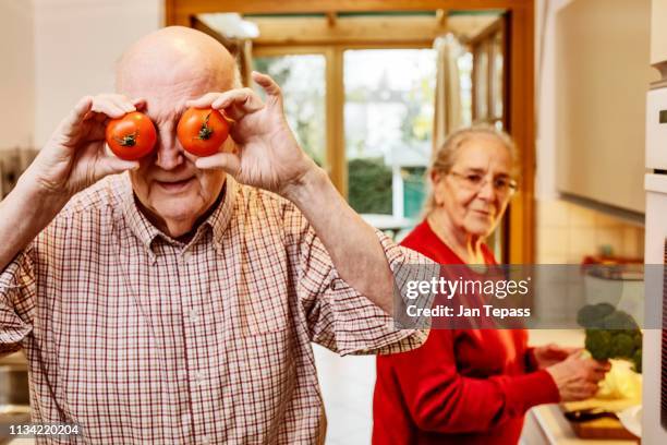 senior is cooking tomatoes with his woman, germany - couple de vieux drole photos et images de collection