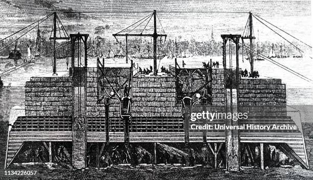 Illustration showing Cross-section showing men working in a caisson used to build one of the piers of the Brooklyn Bridge. During the work. There...