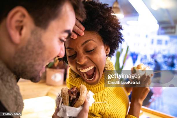 friends playing while eating a burger - veggie burger stock pictures, royalty-free photos & images