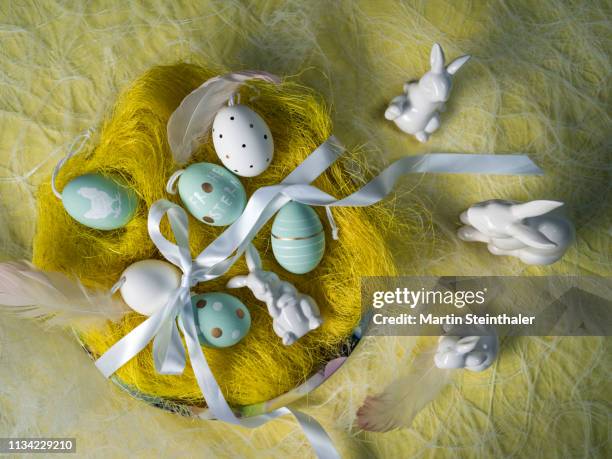 frohe ostern - hasen und eier im osternest - osterkorb stockfoto's en -beelden