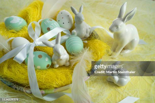 frohe ostern - hasen und eier im osternest - osterkorb stock pictures, royalty-free photos & images