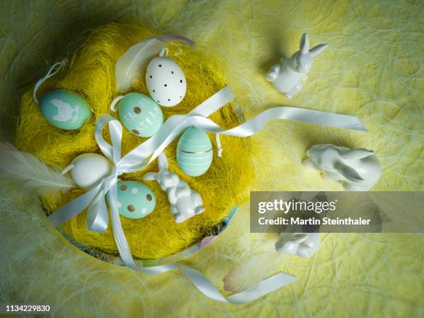 frohe ostern - hasen und eier im osternest - osterkorb stock pictures, royalty-free photos & images