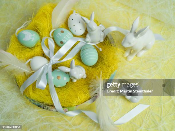 frohe ostern - hasen und eier im osternest - osterei stock pictures, royalty-free photos & images