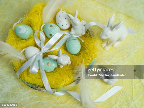 frohe ostern - hasen und eier im osternest - osterkorb stock pictures, royalty-free photos & images