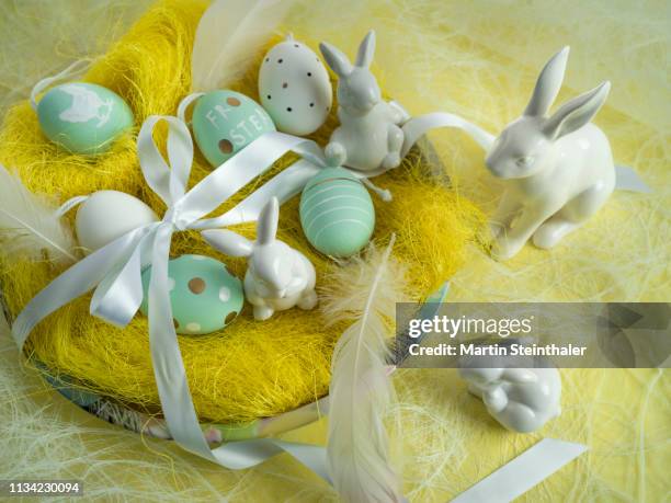 frohe ostern - hasen und eier im osternest - osterkorb stock pictures, royalty-free photos & images