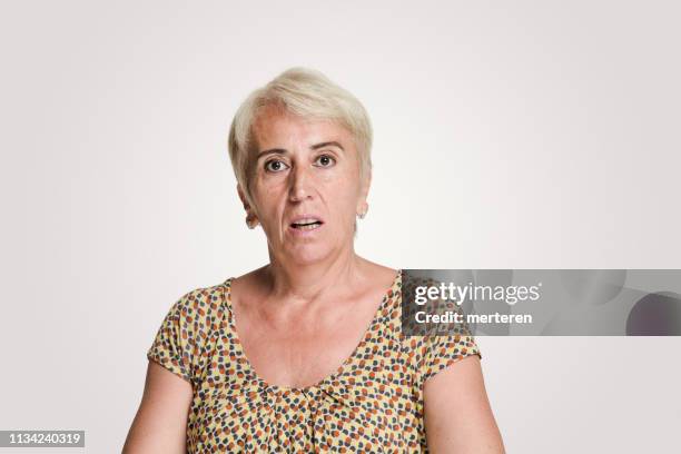 mid volwassen vrouwen kijken naar camera met een shock expression - confused woman stockfoto's en -beelden