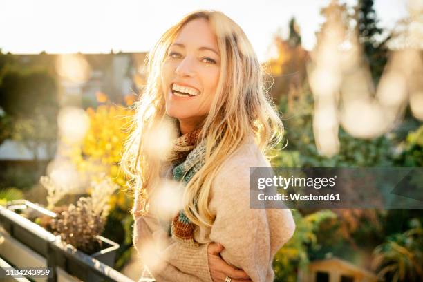 portrait of laughing blond mature woman on balcony at autumn - female soles fotografías e imágenes de stock