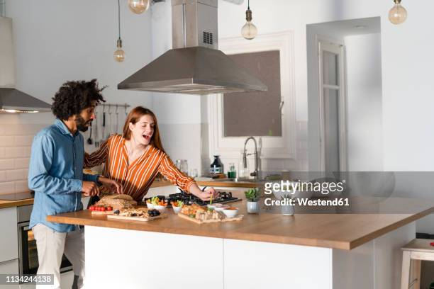 couple standing in kitchen, preparing dinner party - couple cooking photos et images de collection