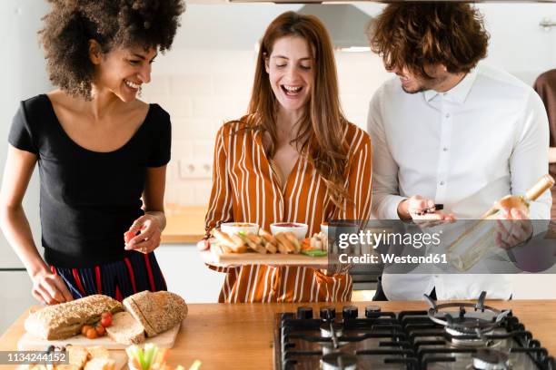 freinds preparing dinner party in the kitchen - the party inside stock pictures, royalty-free photos & images