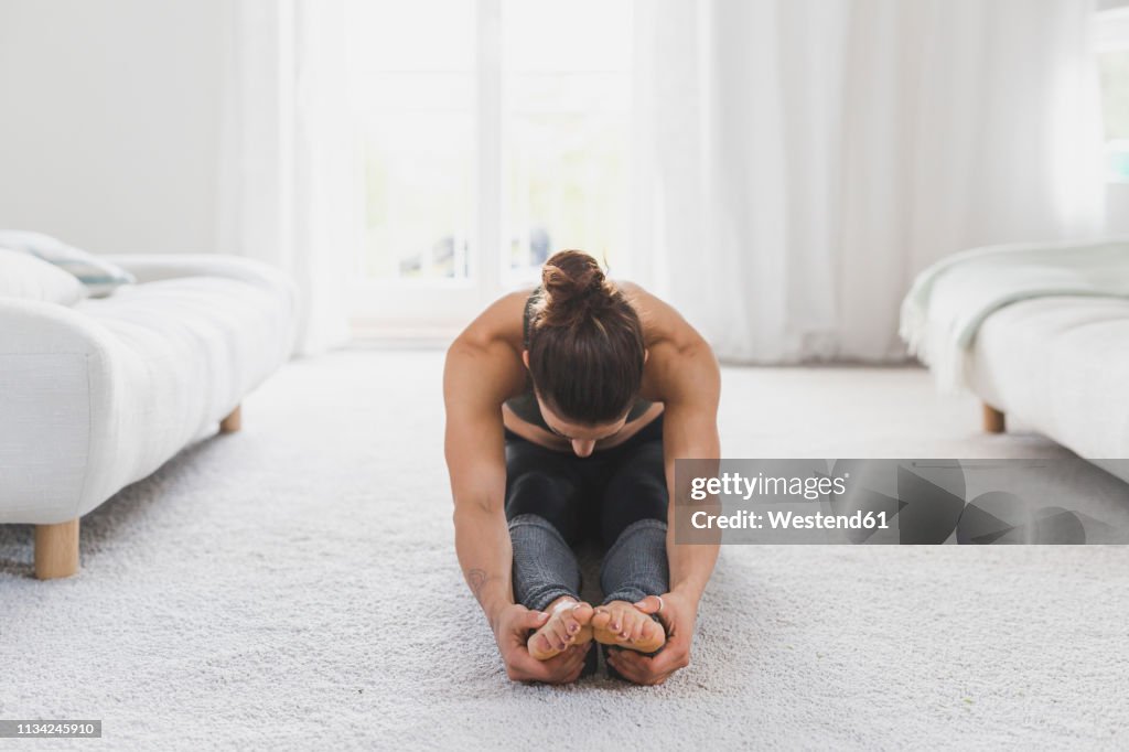 Woman sitting on the floor practicing yoga