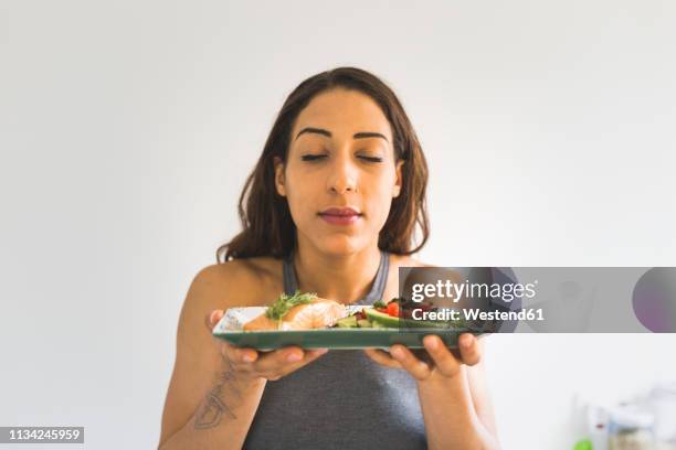 woman holding plate with vegetables and salmon - smelling food stock pictures, royalty-free photos & images