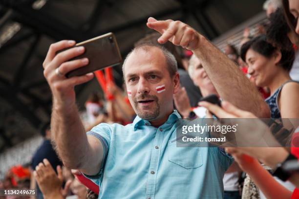 man taking a selfie at a footbal match - spectator selfie stock pictures, royalty-free photos & images