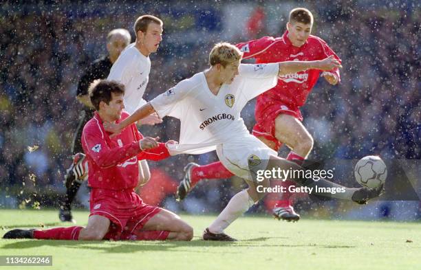 Leeds United striker Alan Smith gets in a shot at goal despite the shirt pulling attentions of Liverpool player Markus Babbel as a young Steven...