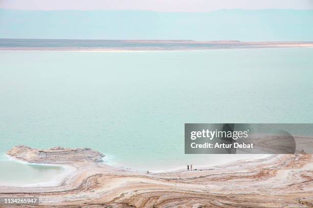 stunning colors of the dead sea with tiny people. - mar morto - fotografias e filmes do acervo