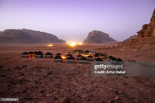 the stunning landscape of the wadi rum with tent camp during twilight. - desert camping stock pictures, royalty-free photos & images