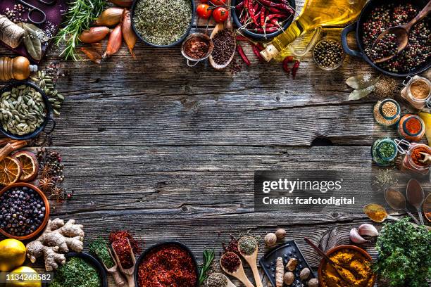 spices and herbs frame shot from above on rustic wooden table - chili oil stock pictures, royalty-free photos & images
