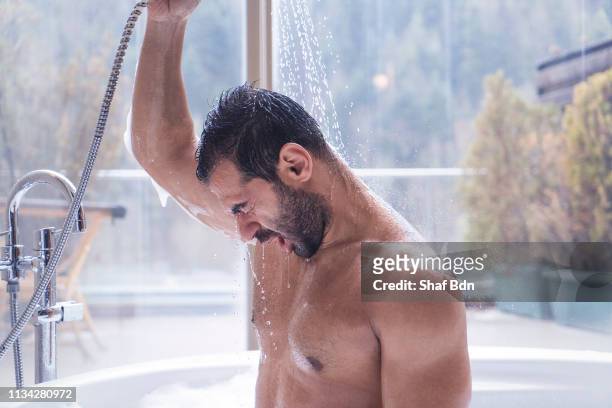 man having shower in a hot tub with a forest view - moving activity stock pictures, royalty-free photos & images
